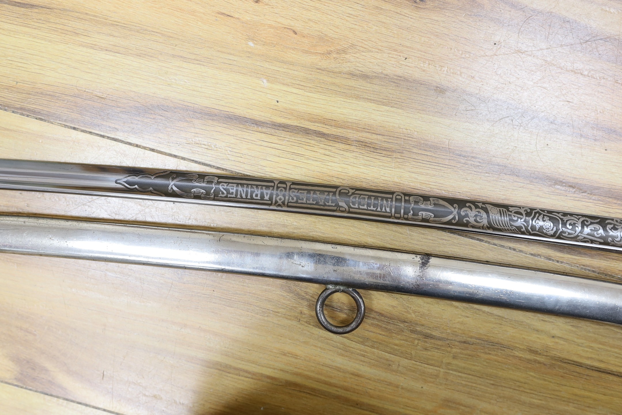 A United States Marines dress sword made by Wilkinson, the blade etched ‘S/SGT. JAMES P.S. DEVEREUX II. 1340836 U.S.M.C.’ with scabbard. Total length 107cm